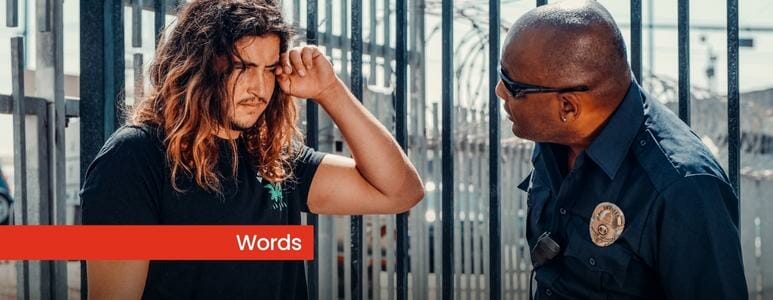 Police Officer Wearing Sunglasses Talking To Long Haired Man